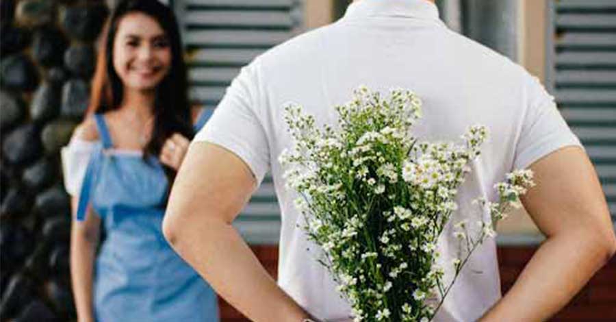 man facing a girl while holding flowers